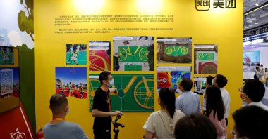 Visitors stand near a Meituan shared bicycle displayed at the booth of the food delivery giant at the 2021 China International Fair for Trade in Services (CIFTIS) in Beijing, China, Sept. 3, 2021. (Reuters Photo)