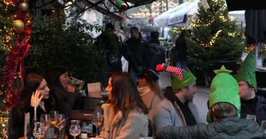 People sit outside bars and cafes in the center of Amsterdam, the Netherlands, Dec. 18, 2021. (AP Photo)