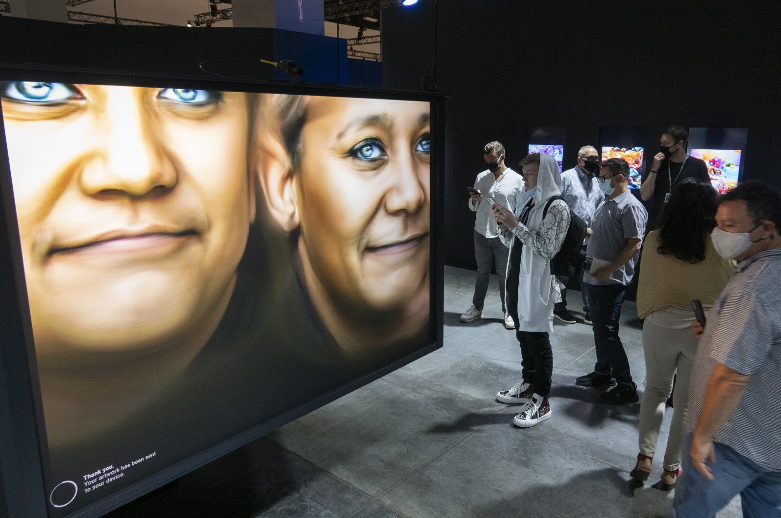 People take in the &quot;Human   Machine&quot; NFTS art exhibition, during the general public opening day of the Art Basel Miami Beach fair at the Miami Beach Convention Center in Miami, Florida, U.S., Dec. 2, 2021. (EPA Photo)