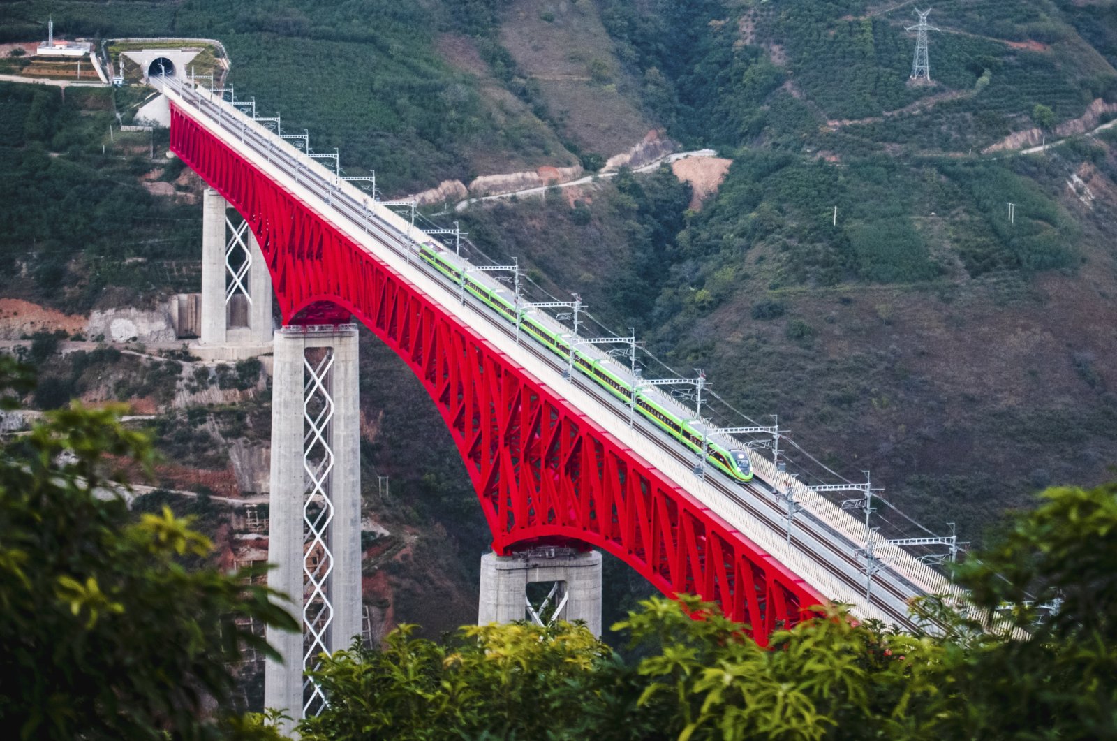 An electric multiple unit (EMU) train of the China-Laos Railway crosses a major bridge over the Yuanjiang River in southwestern China&#039;s Yunnan Province, Friday, Dec. 3, 2021. (Xinhua News Agency via AP)