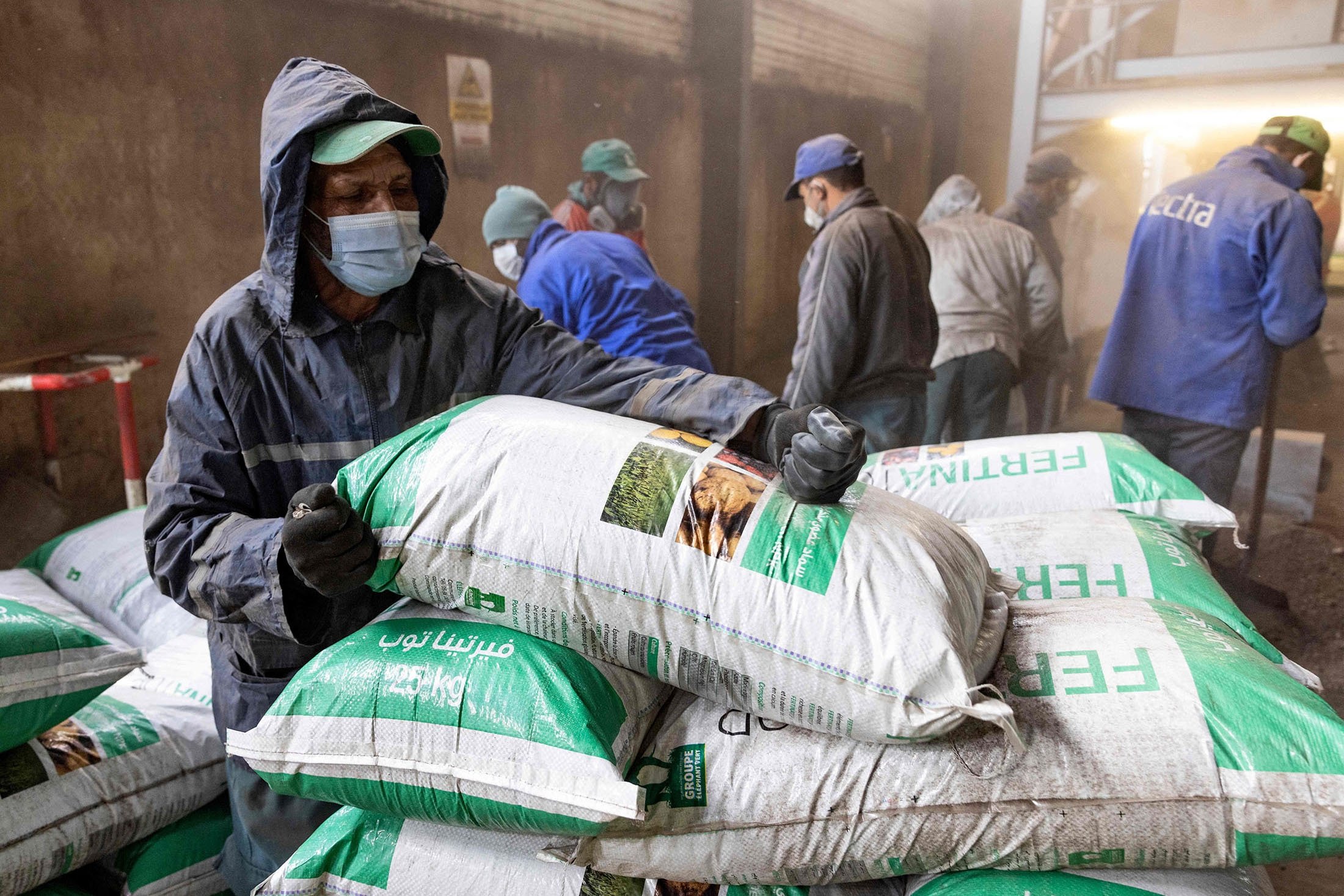 Workers fill bags with fertilizer in the Elephant Vert factory in the 'Agropolis' industrial zone in northern city of Meknes, Morocco, Dec. 9, 2021. (AFP Photo)