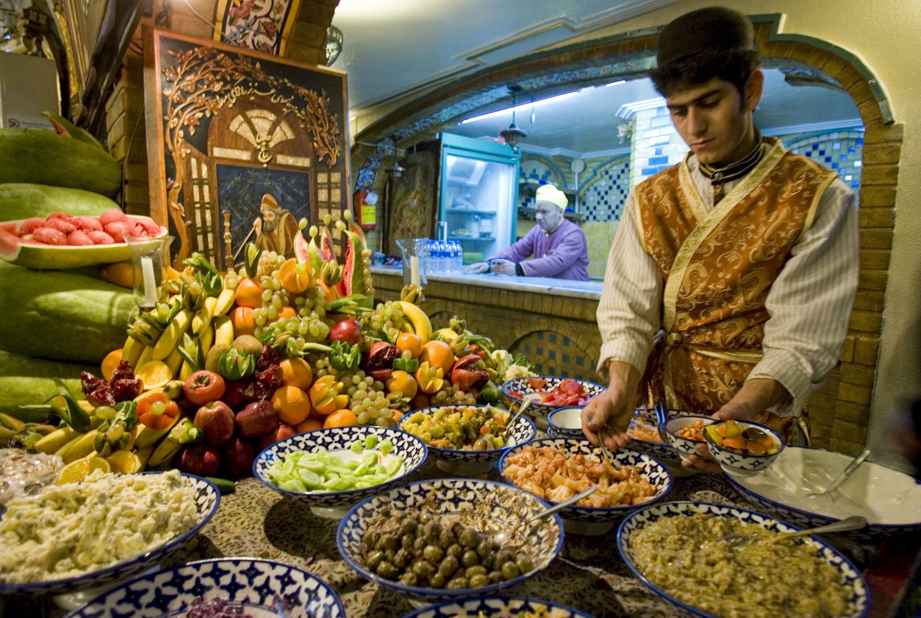 A waiter prepares dishes to be served to customers in a traditional restaurant during the celebrations of the 