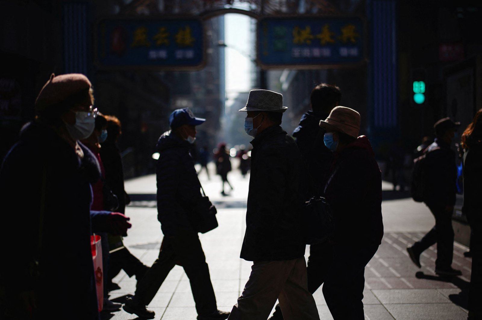 People wearing protective masks walk on a street, Shanghai, China, Dec. 20, 2021. (Reuters Photo)