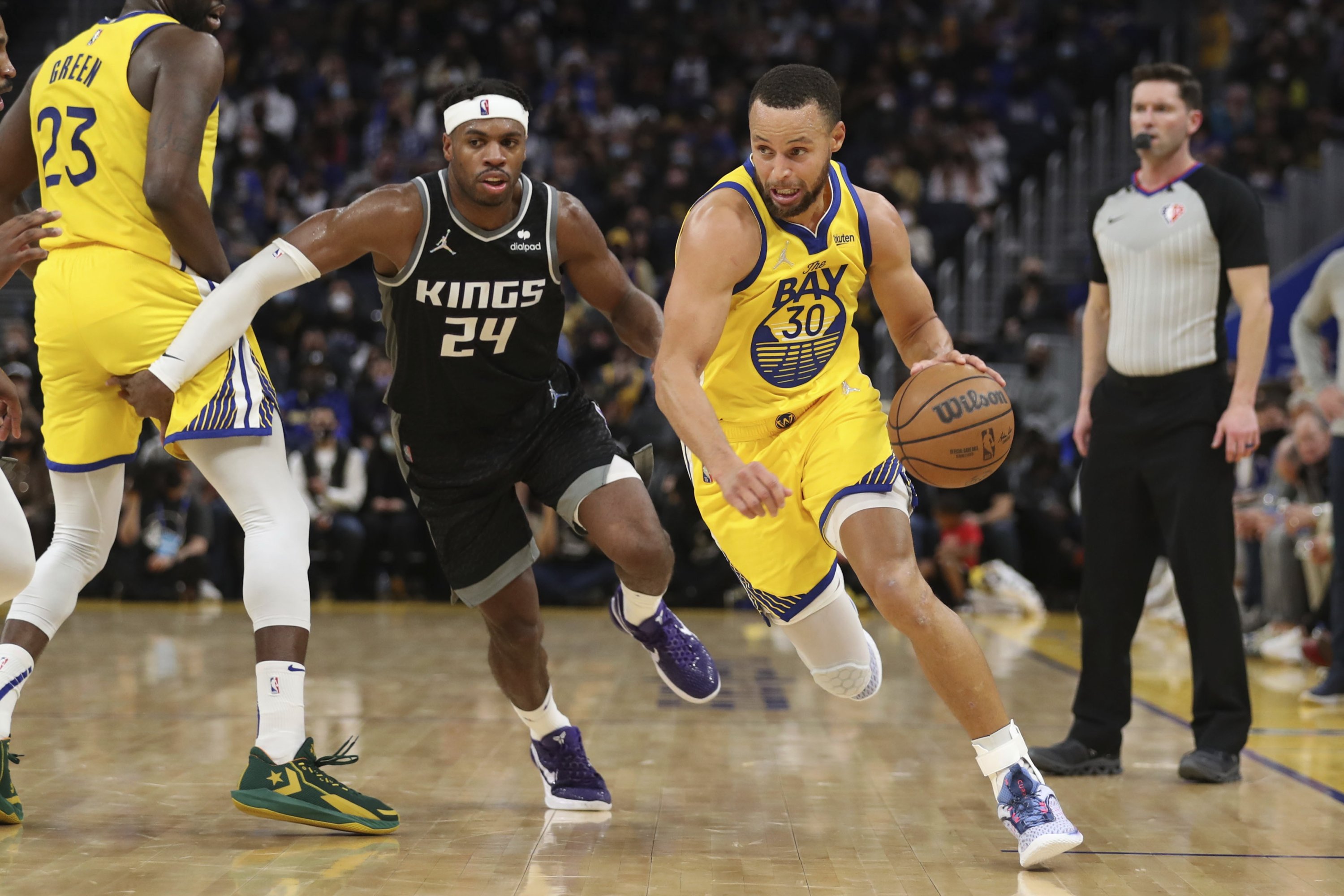 Golden State Warriors' Stephen Curry (R) drives to the basket against Sacramento Kings guard Buddy Hield (C) in an NBA game, San Francisco, U.S., Dec. 20, 2021. (AP Photo)