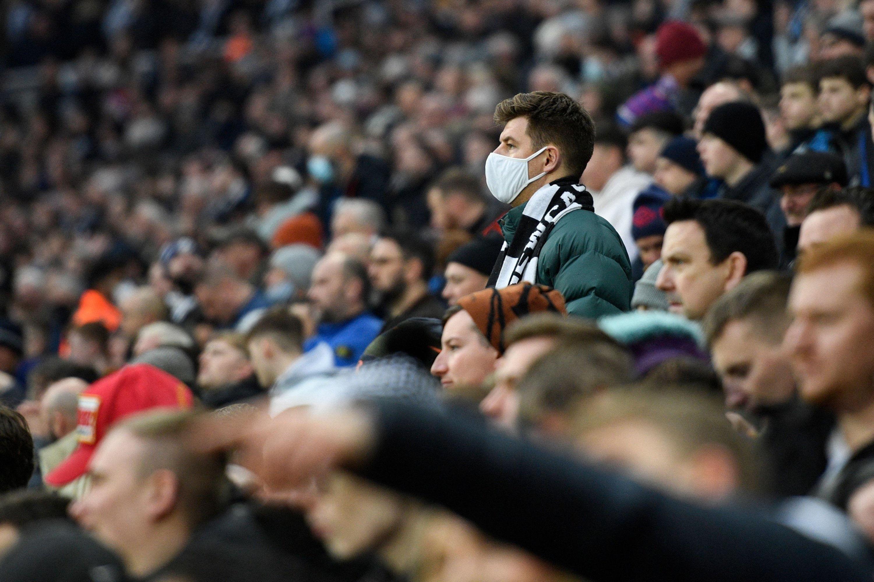 A fan wearing a face mask against the coronavirus looks on during a Premier League football match, Newcastle-upon-Tyne, England, Dec. 19, 2021. (AFP Photo)
