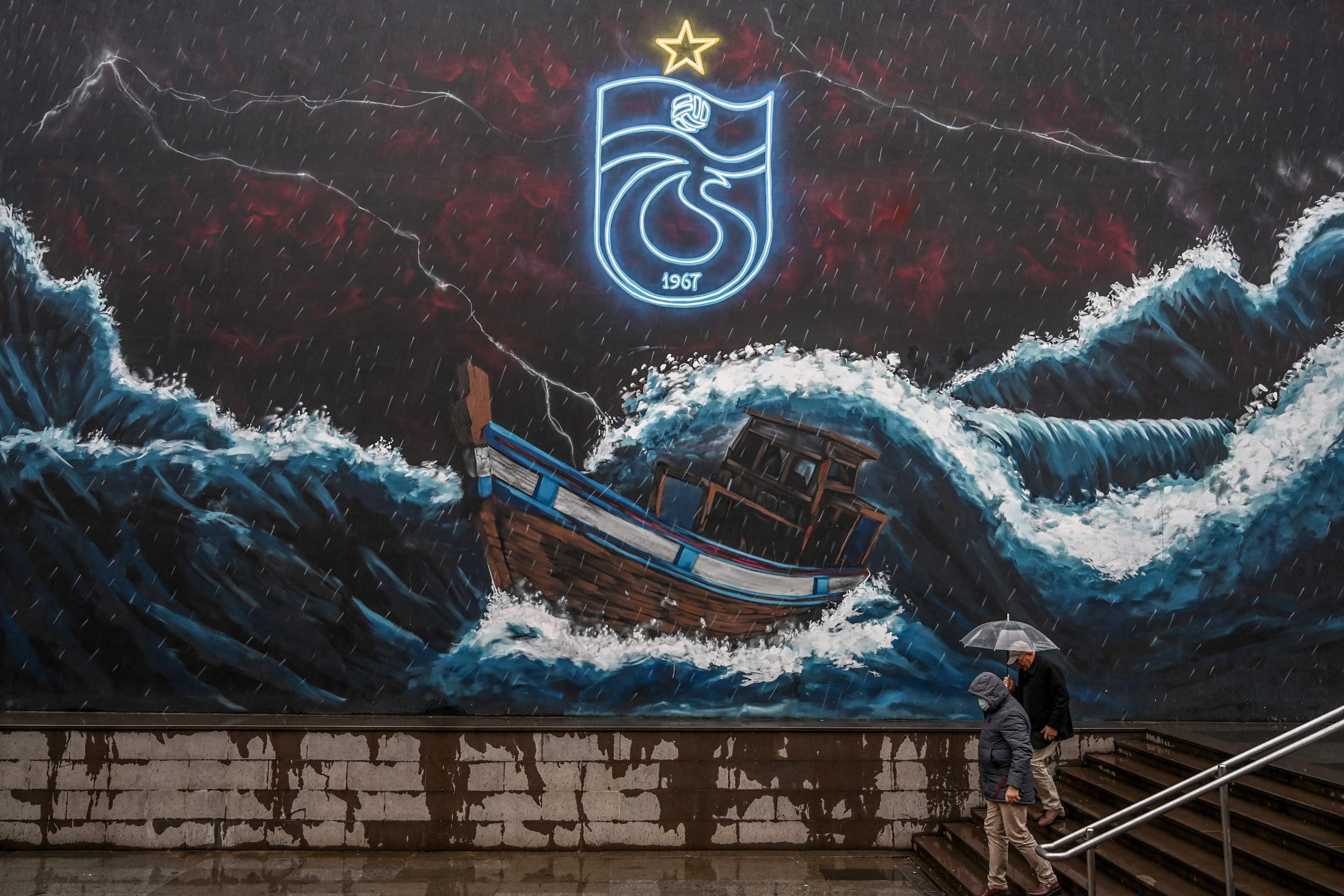 Pedestrians walk past a giant graffiti of the Trabzonspor club in Trabzon, Turkey, Dec. 18, 2021. (AFP Photo)