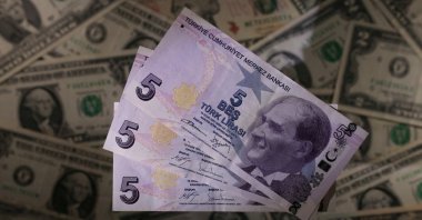 Turkish lira banknotes are seen placed on U.S. dollar banknotes in this illustration created on Nov. 28, 2021. (Reuters Photo)