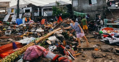 A woman tends to her damaged properties following typhoon Rai, in Surigao City, Surigao del Norte, Philippines, Dec. 19, 2021. (Jilson Tiu/Greenpeace/Handout via Reuters)