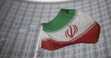 A national flag of Iran waves in front of the building of the International Atomic Energy Agency, IAEA, in Vienna, Austria, Dec. 17, 2021. (AP Photo)