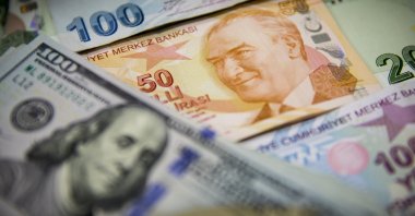 The Turkish lira and U.S. dollar banknotes are pictured together in a photo taken in Turkey. (Photo by Getty Images)