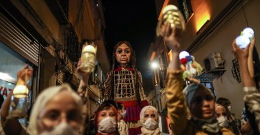 A giant puppet of a young refugee girl Amal is carried on the street by Syrian refugees children in Gaziantep, Turkey, 27 July 2021. (EPA Photo)