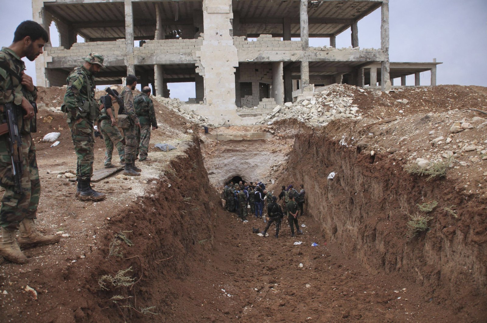 Assad regime forces stand in a trench near a glass factory after regaining control of the area, northeast Aleppo, Syria, Oct.19, 2014. (Reuters File Photo)