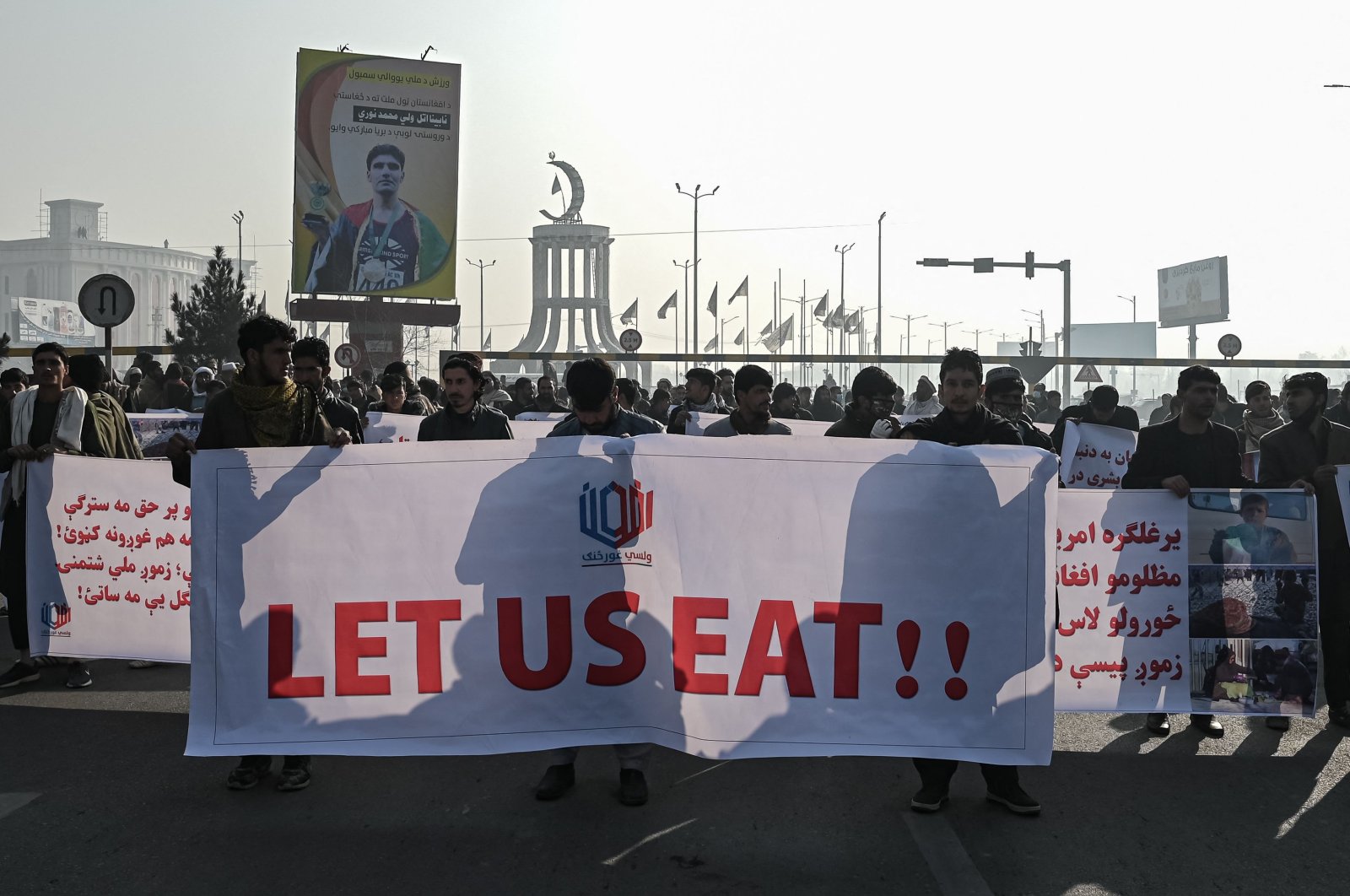 People hold a banner reading &#039;Let us eat&#039; before marching on the street during a protest in Kabul, Afghanistan, Dec. 21, 2021. (AFP Photo)