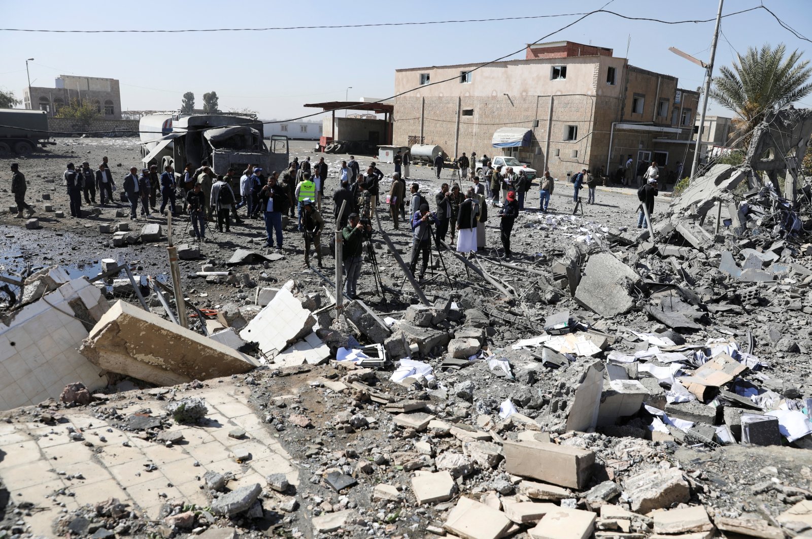 Journalists and airport staffers gather by the rubble of a building destroyed by Saudi-led airstrikes at Sanaa Airport in Sanaa, Yemen, Dec. 21, 2021. (Reuters Photo)