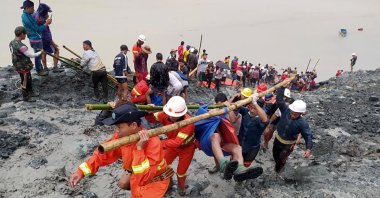Rescue workers carry the body of a victim after a landslide accident at a jade mining site in Hpakant, Kachin State, Myanmar, July 2, 2020. (EPA-EFE/Myanmar Fire Services Department)