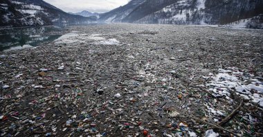 Plastic bottles and other garbage float in Potpecko lake near Priboj, southwest Serbia, Jan. 22, 2021. (AP Photo)