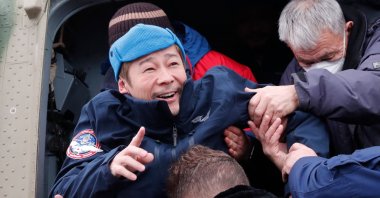 Japanese billionaire Yusaku Maezawa is helped to disembark from a helicopter as he arrives at Zhezkazgan airport after returning from the International Space Station (ISS) on the Soyuz MS-20 space capsule, in Zhezkazgan, Kazakhstan, Dec. 20, 2021. (AFP Photo)