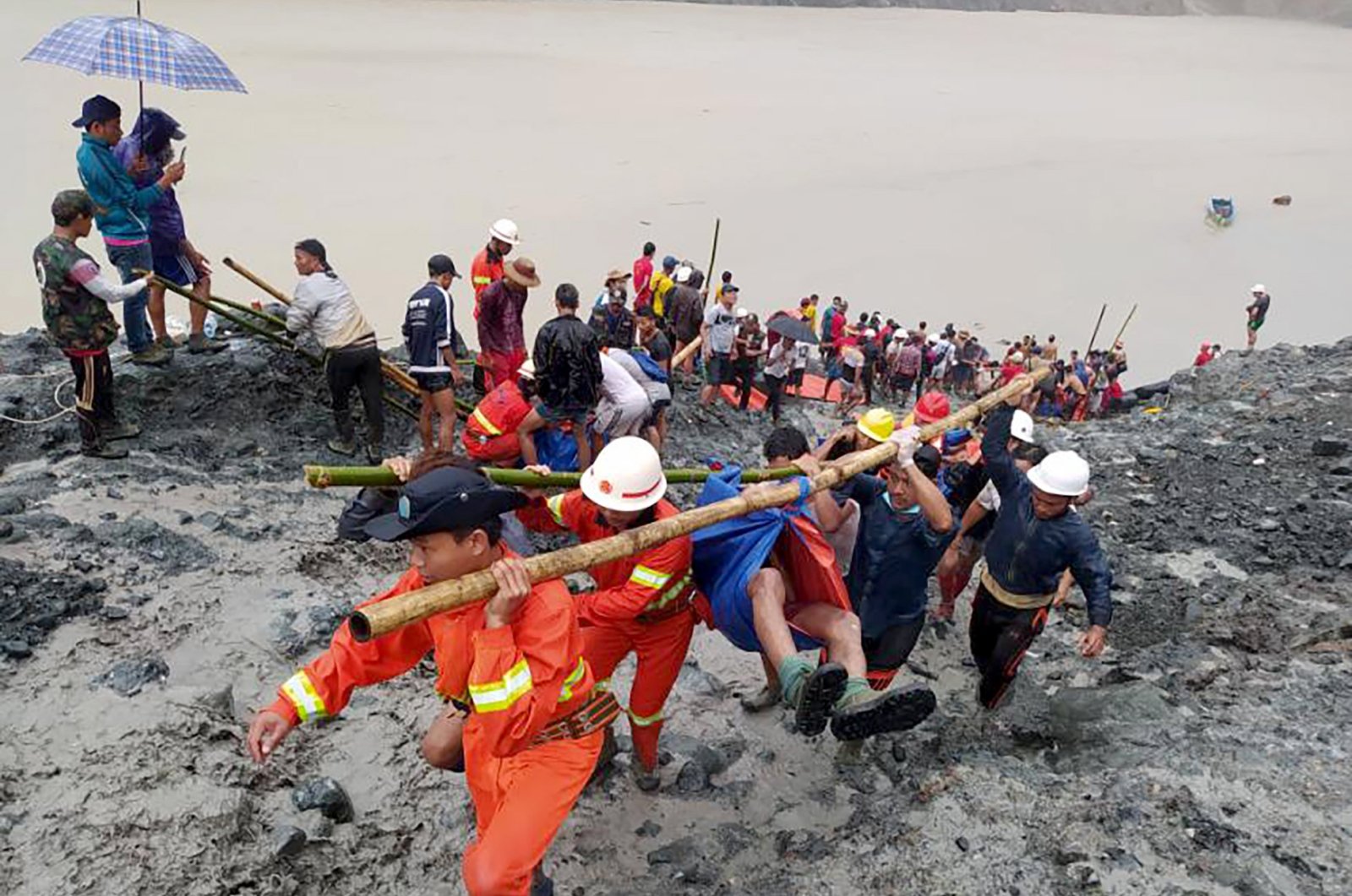 Rescue workers carry the body of a victim after a landslide accident at a jade mining site in Hpakant, Kachin State, Myanmar, July 2, 2020. (EPA-EFE/Myanmar Fire Services Department)