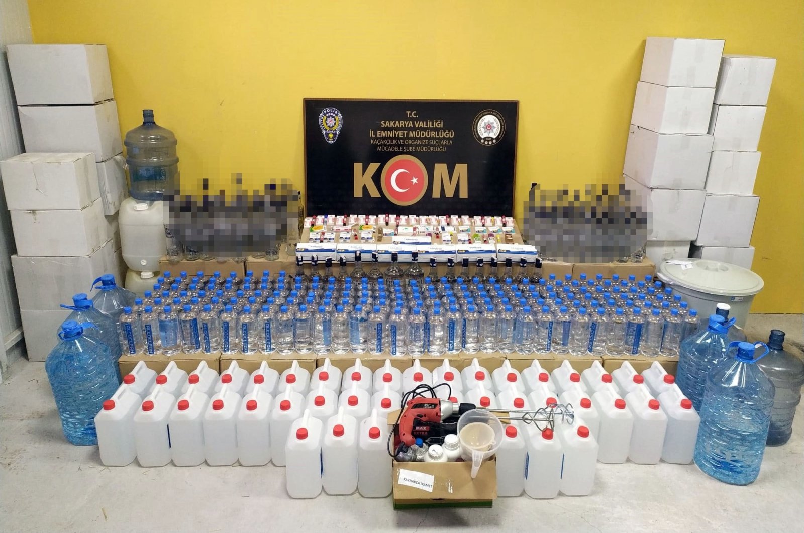 Police in northwestern Sakarya province exhibit gallons containing ethyl alcohol, empty bottles and other equipment used in bootleg liquor production, Turkey, Dec. 22, 2021. (IHA Photo)