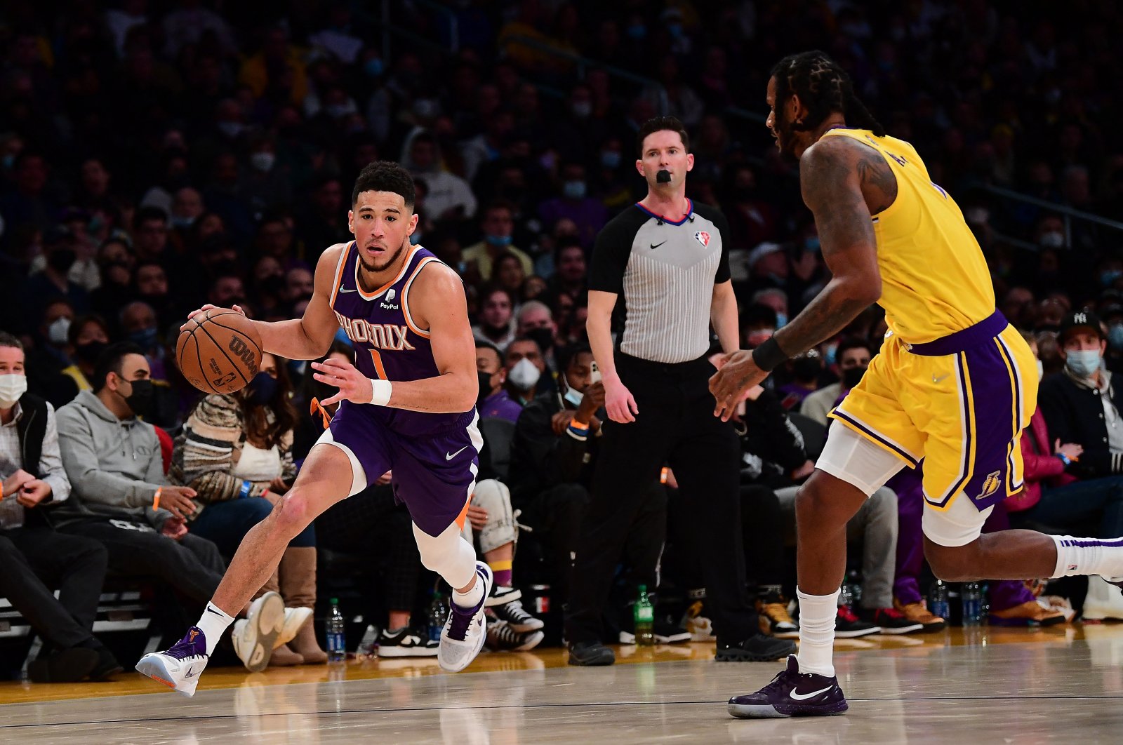 Phoenix Suns guard Devin Booker (L) goes past Los Angeles Lakers forward Trevor Ariza (R) during an NBA game at Staples Center, Los Angeles, California, U.S., Dec. 21, 2021. (Reuters Photo)