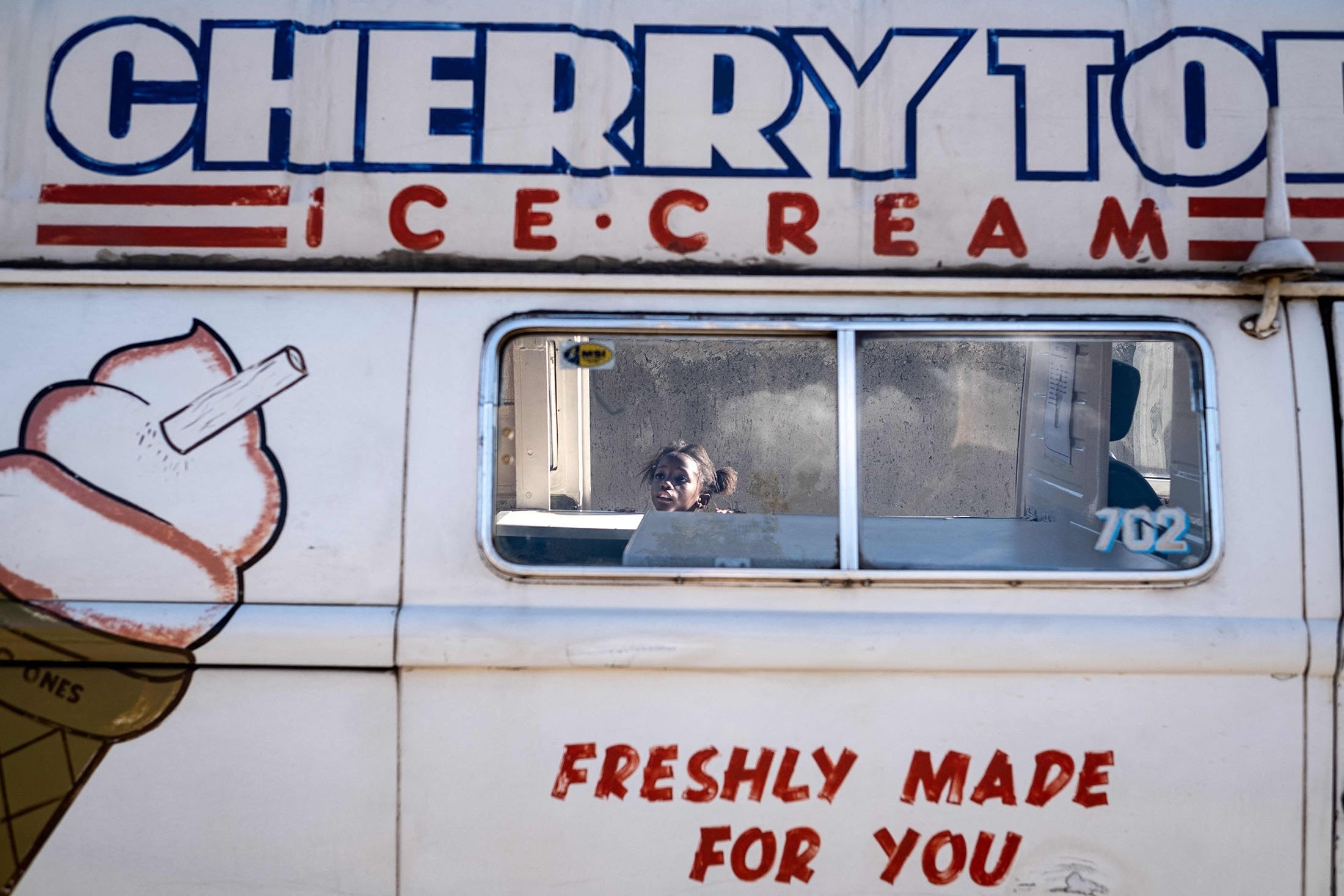 A child looks into Sipho Mtshaliís ice cream truck in Soweto, South Africa, Nov. 19, 2021. (AFP Photo)