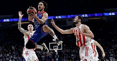 Anadolu Efes' Shane Larkin (C) goes past two Crvena Zvezda players in an EuroLeague match, Istanbul, Turkey, Dec. 23, 2021. (AA Photo)