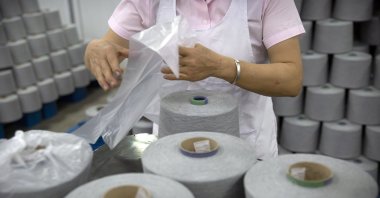 A worker packages spools of cotton yarn at a textile manufacturing plant, as seen during a government organized trip for foreign journalists, in Aksu in western China&#039;s Xinjiang Uyghur Autonomous Region, Tuesday, April 20, 2021. (AP Photo)