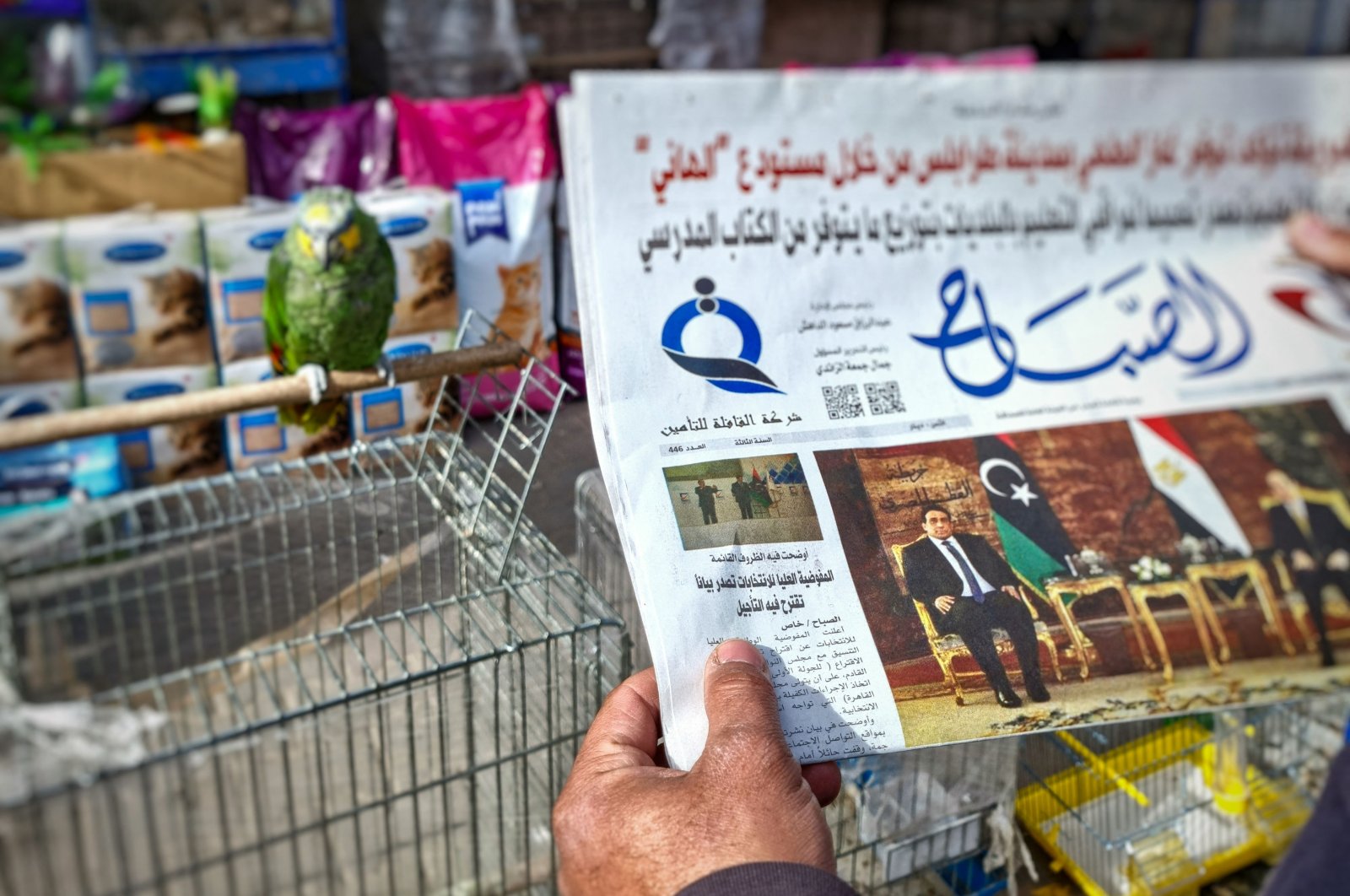 A man reads a local newspaper in the Libyan capital Tripoli, on Dec. 23, 2021, with an article on its front page about the postponement of the country&#039;s presidential elections. (AFP Photo)