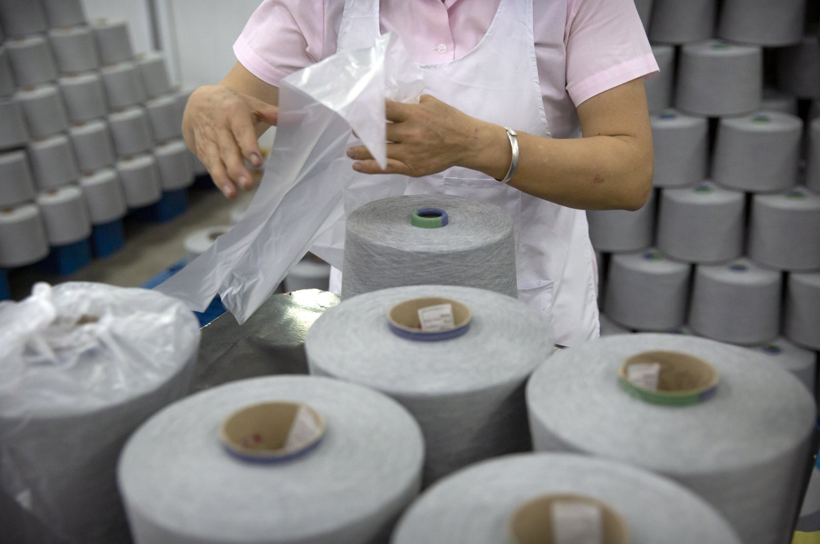 A worker packages spools of cotton yarn at a textile manufacturing plant, as seen during a government organized trip for foreign journalists, in Aksu in western China&#039;s Xinjiang Uyghur Autonomous Region, Tuesday, April 20, 2021. (AP Photo)