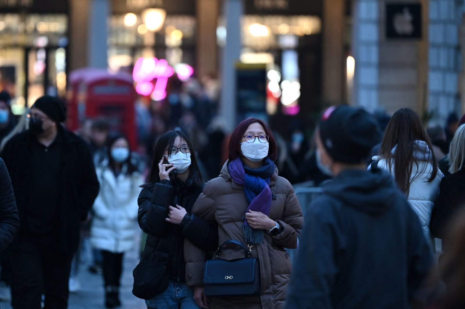 Shoppers wearing face coverings to combat the spread of COVID-19, pass through the Covent Garden area of London on Dec. 21, 2021. (AFP Photo)