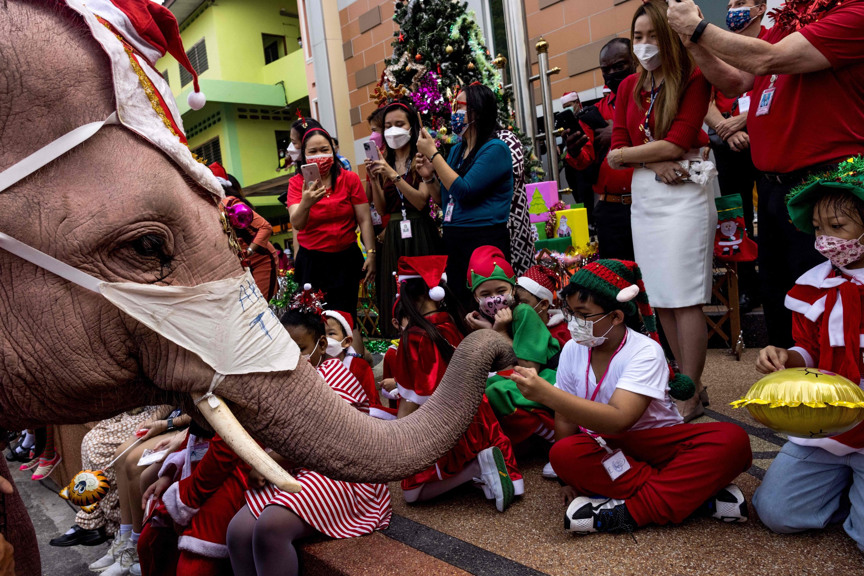 An elephant hands out gifts to children during Christmas celebrations at the Jirasart Witthaya school in Ayutthaya, Thailand, December 24, 2021. (AFP Photo)