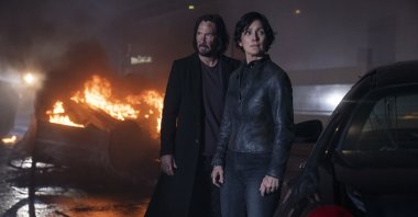 Keanu Reeves (L) and Carrie-Anne Moss, in a scene from the film &quot;The Matrix Resurrections.&quot; (Warner Bros. via AP)