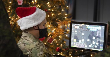 In this photo provided by the North American Aerospace Defense Command, a 22 Wing member is seen showing how they track Santa on his sleigh on Christmas Eve during a media preview at the Canadian Forces Base in North Bay, Canada, Dec. 9, 2021. (NORAD via AP)