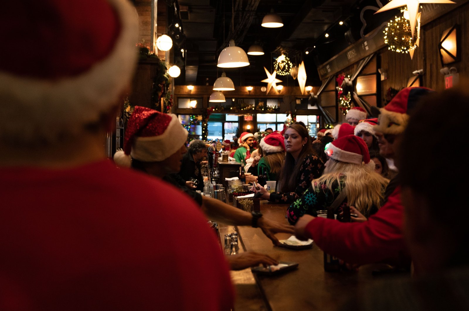 People dressed in Santa Claus costumes order drinks at Mustang Harry&#039;s during SantaCon, New York, U.S., Dec. 11, 2021. (AFP Photo)