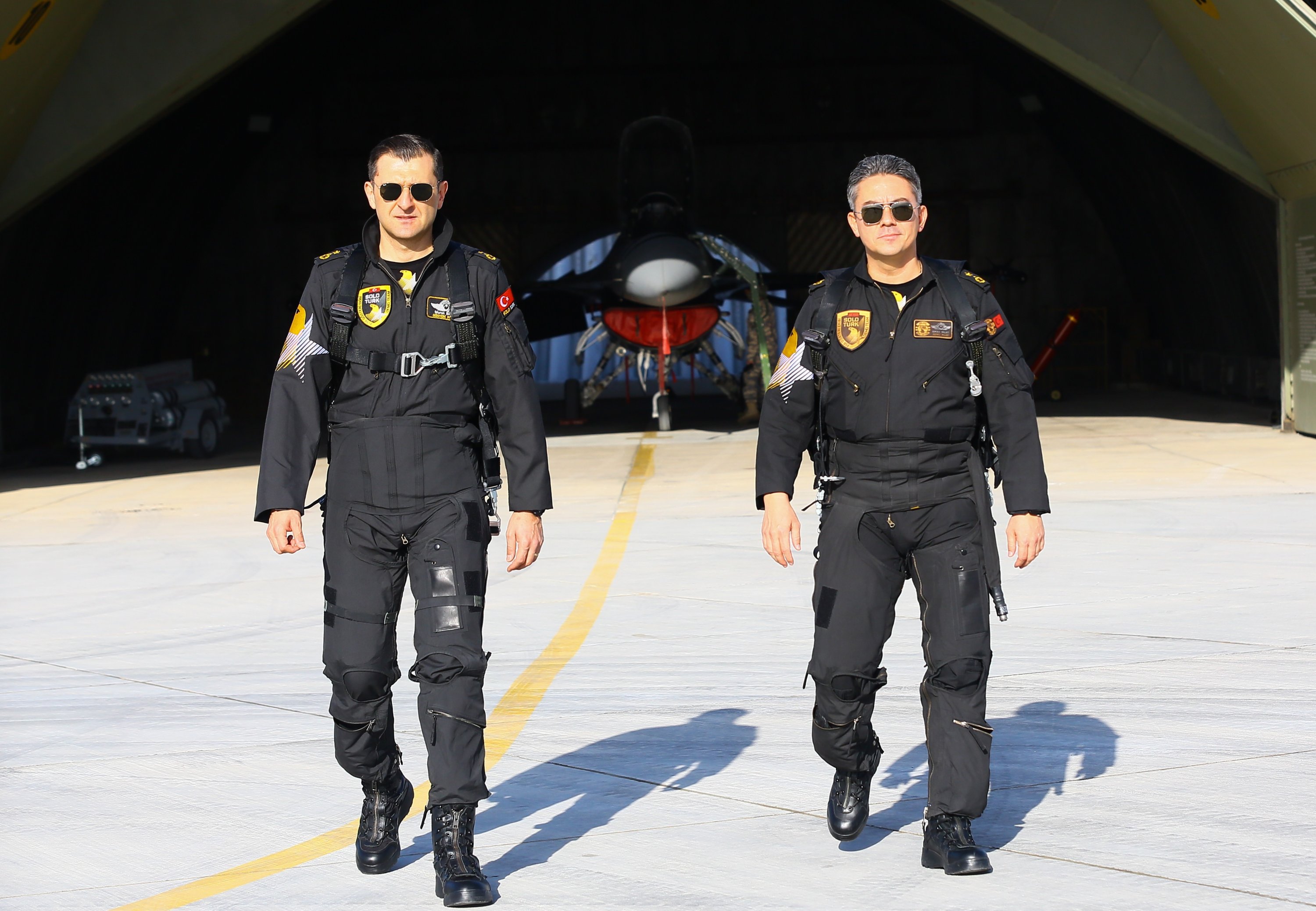 Dua anggota SOLOTÜRK, tim aerobatik Komando Angkatan Udara Turki, di landasan pacu, Ankara, Turki, 25 Desember 2021.