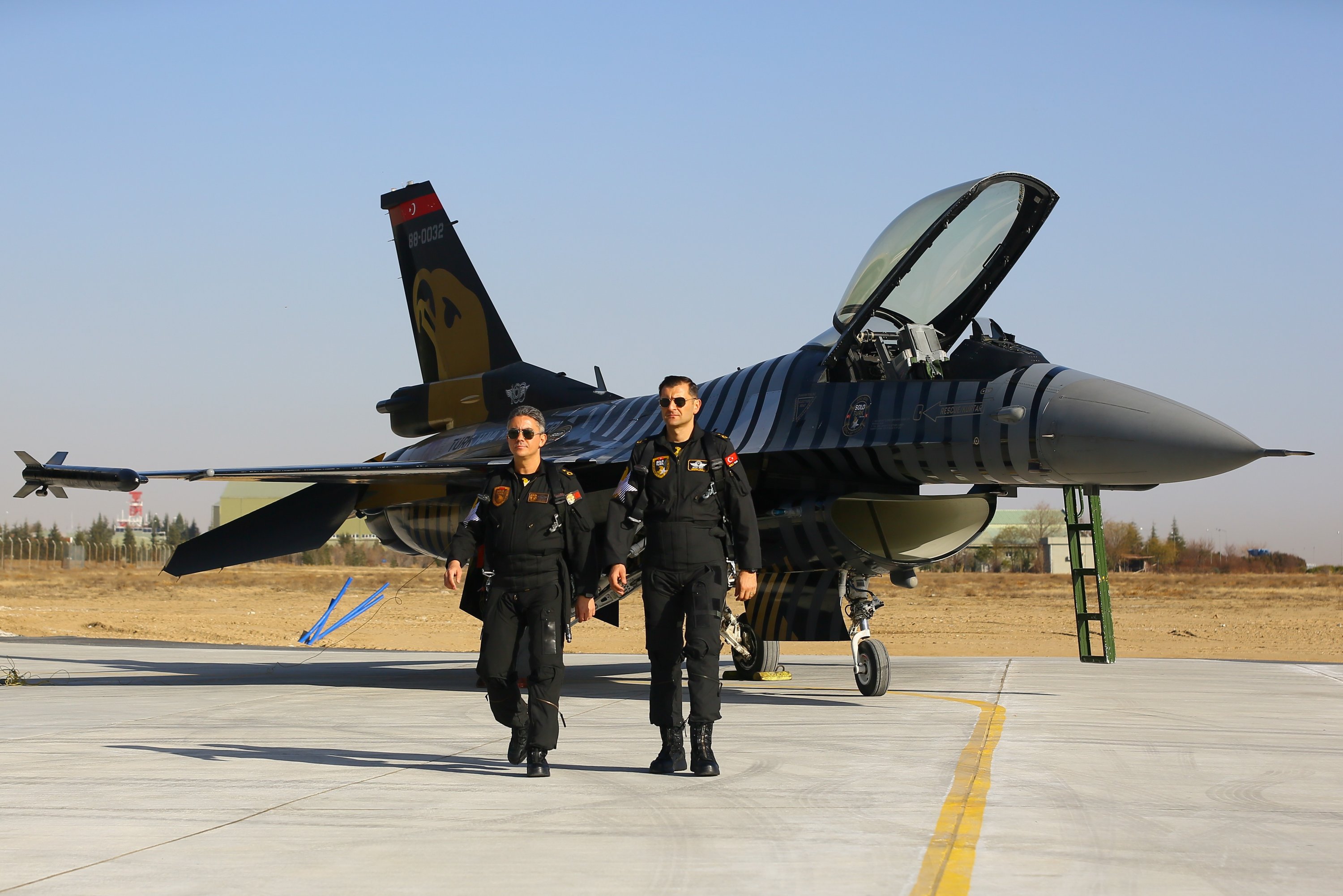 Two members of SOLOTÜRK, the Turkish Air Forces Command's aerobatics team, and their F-16 fighter jet on the tarmac, Ankara, Turkey, Dec. 25, 2021.