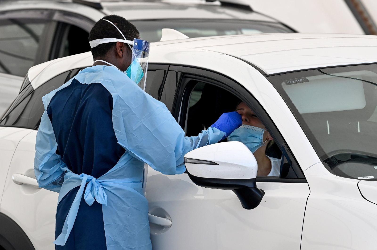 Healthcare workers administer COVID-19 tests at the St Vincent’s Hospital drive-through testing clinic at Bondi Beach in Sydney, Australia, Dec. 19, 2021. (EPA Photo)