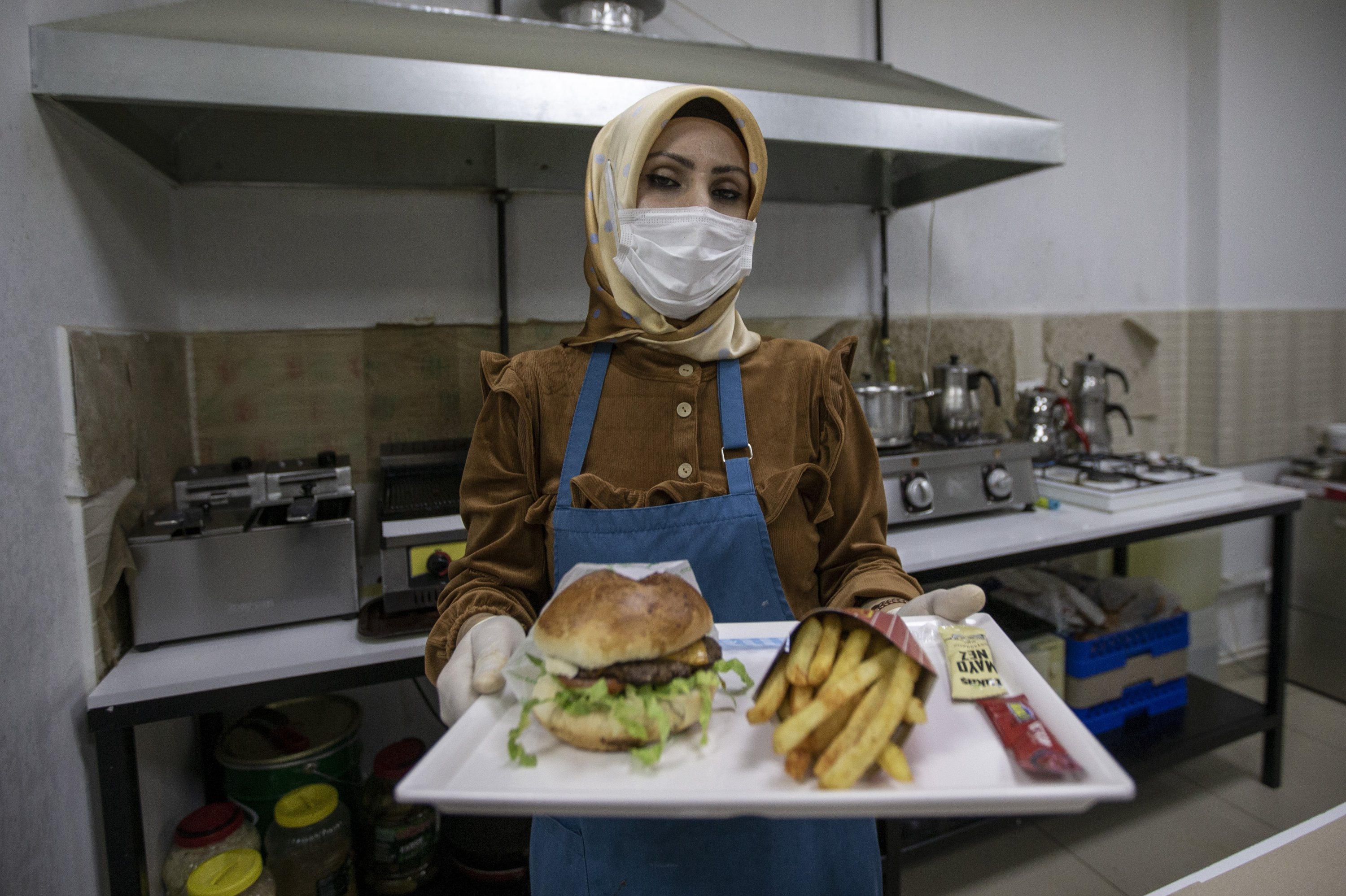 Yasemin Bülbül holding a meal inside her restaurant and cafeteria in Erzurum, eastern Turkey, Dec. 9, 2021. (AA Photo)