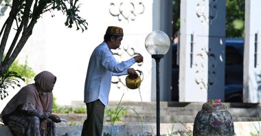 People visit a mass grave memorial at the Siron Tsunami Memorial Park to mark the 17th anniversary of when a 9.1 magnitude earthquake struck the province on Boxing Day in 2004, causing a tsunami that claimed the lives of more than 170,000 people in Indonesia alone, Siron, Aceh province, Indonesia, Dec. 26, 2021.  (Photo by CHAIDEER MAHYUDDIN / AFP)
