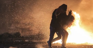 Palestinian protesters flee through tear gas fumes during clashes with Israeli forces near the illegal Israeli outpost of Homesh near the Palestinian village of Burqa, occupied West Bank, Dec. 25, 2021. (AFP Photo)