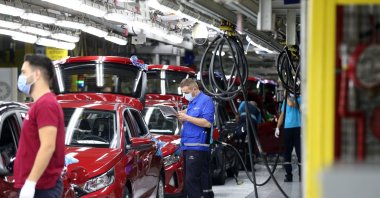 Workers are seen beside new i20 model cars at Hyundai Assan&#039;s Izmit factory in northwestern Kocaeli, Turkey, Aug. 28, 2020. (AA Photo)
