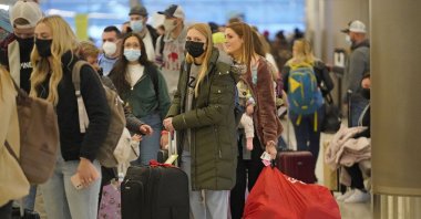Holiday travelers wait in line at Salt Lake City International Airport, in Salt Lake City, Utah, U.S., Dec. 24, 2021. (AP Photo)