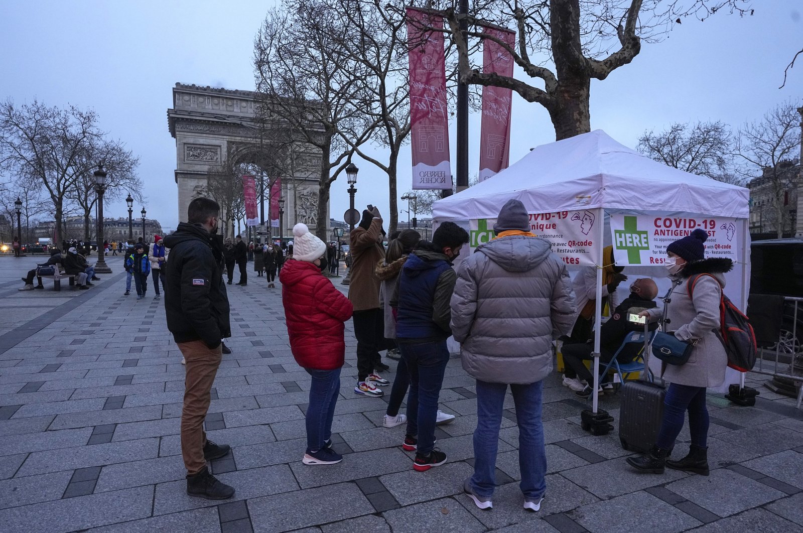 People line up to get a nasal swap at a mobile COVID-19 testing site on Christmas Eve at the Champs Elysees avenue in Paris, Dec. 24, 2021. (AP Photo)