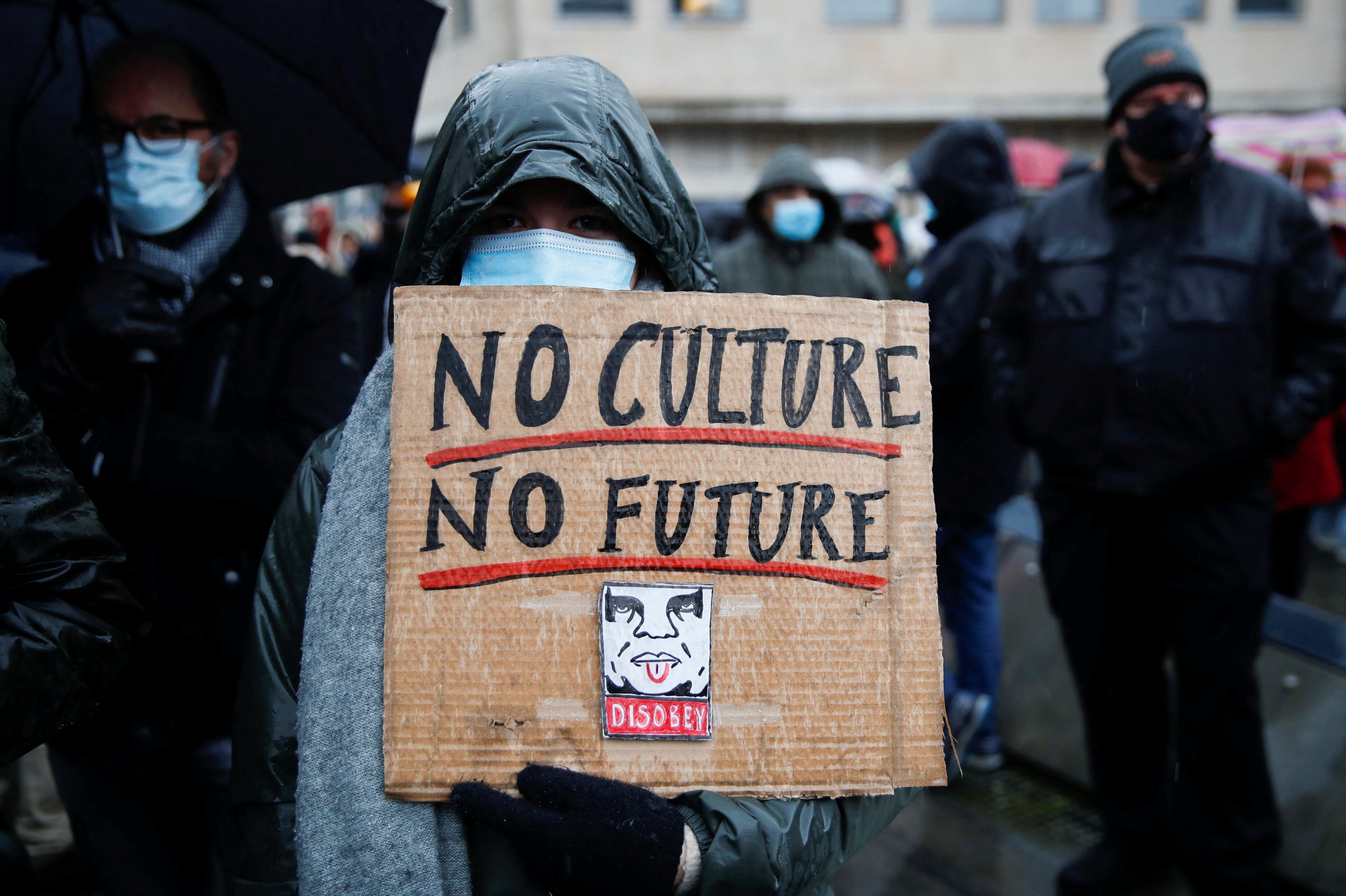 A woman holds a banner reading 'No Culture, No Future' during a demonstration against the Belgian government's restrictions imposed to contain the spread of COVID-19 in Brussels, Belgium, Dec. 26, 2021. REUTERS/Johanna Geron