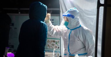 A medical worker takes a swab sample from a resident to be tested for COVID-19 in Xi'an in China's northern Shaanxi province, Dec. 25, 2021. (AFP Photo)