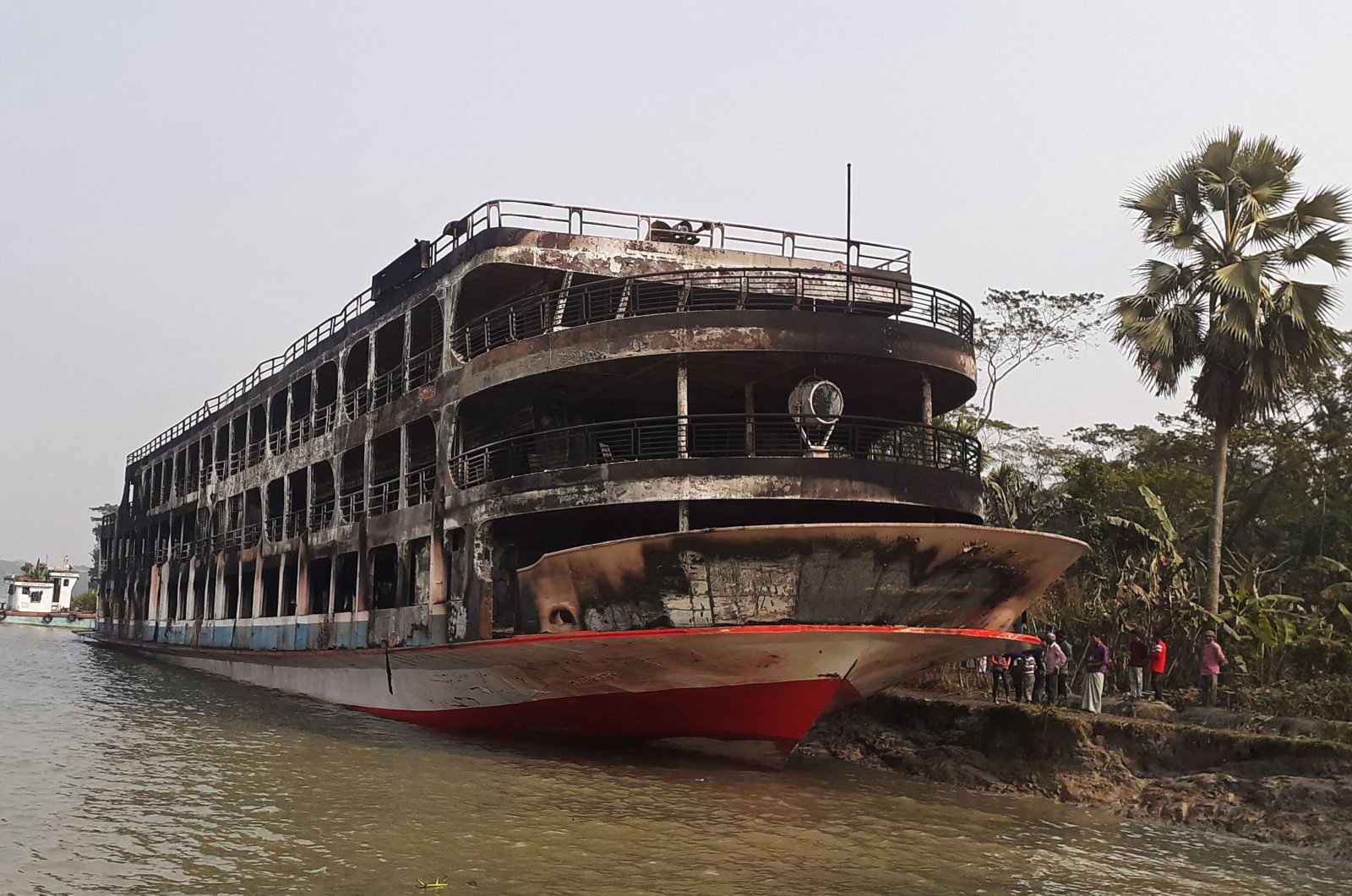 The burnt-out ferry is seen anchored along a coast a day after it caught fire, killing at least 37 people in Jhalkathi, 250 kilometers (160 miles) south of Dhaka, Dec. 24, 2021. (AFP Photo)