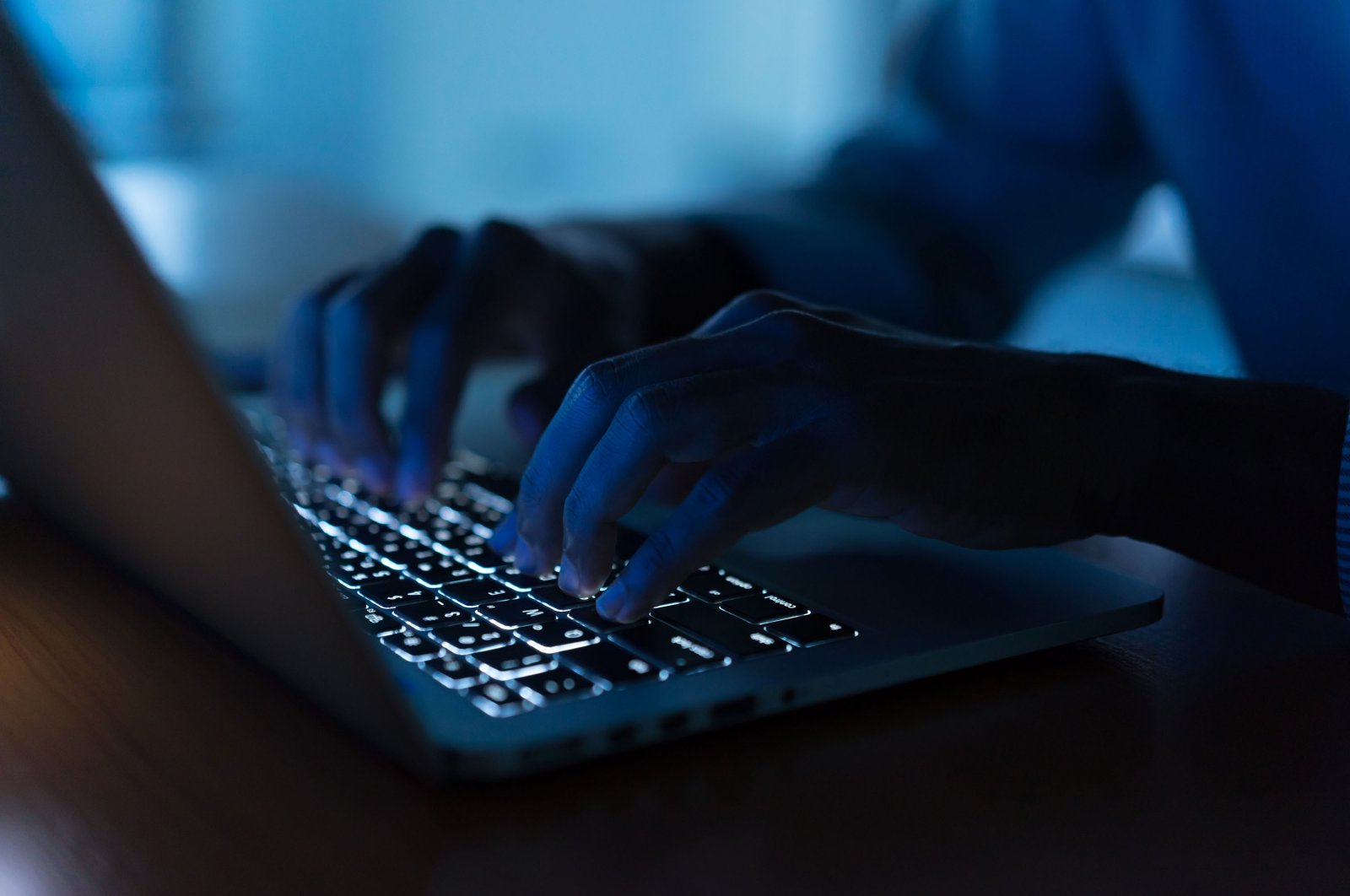 Man types on a laptop in the darkness in this undated file photo. (Shutterstock File Photo)