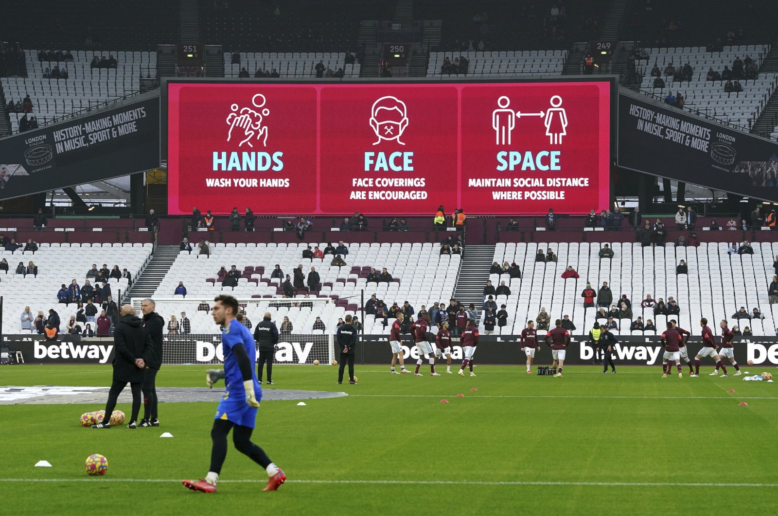 COVID-19 safety signage are seen above the stands before the English Premier League soccer match between West Ham and Southampton, at the London Stadium, U.K., Dec. 26, 2021. (AP Photo)