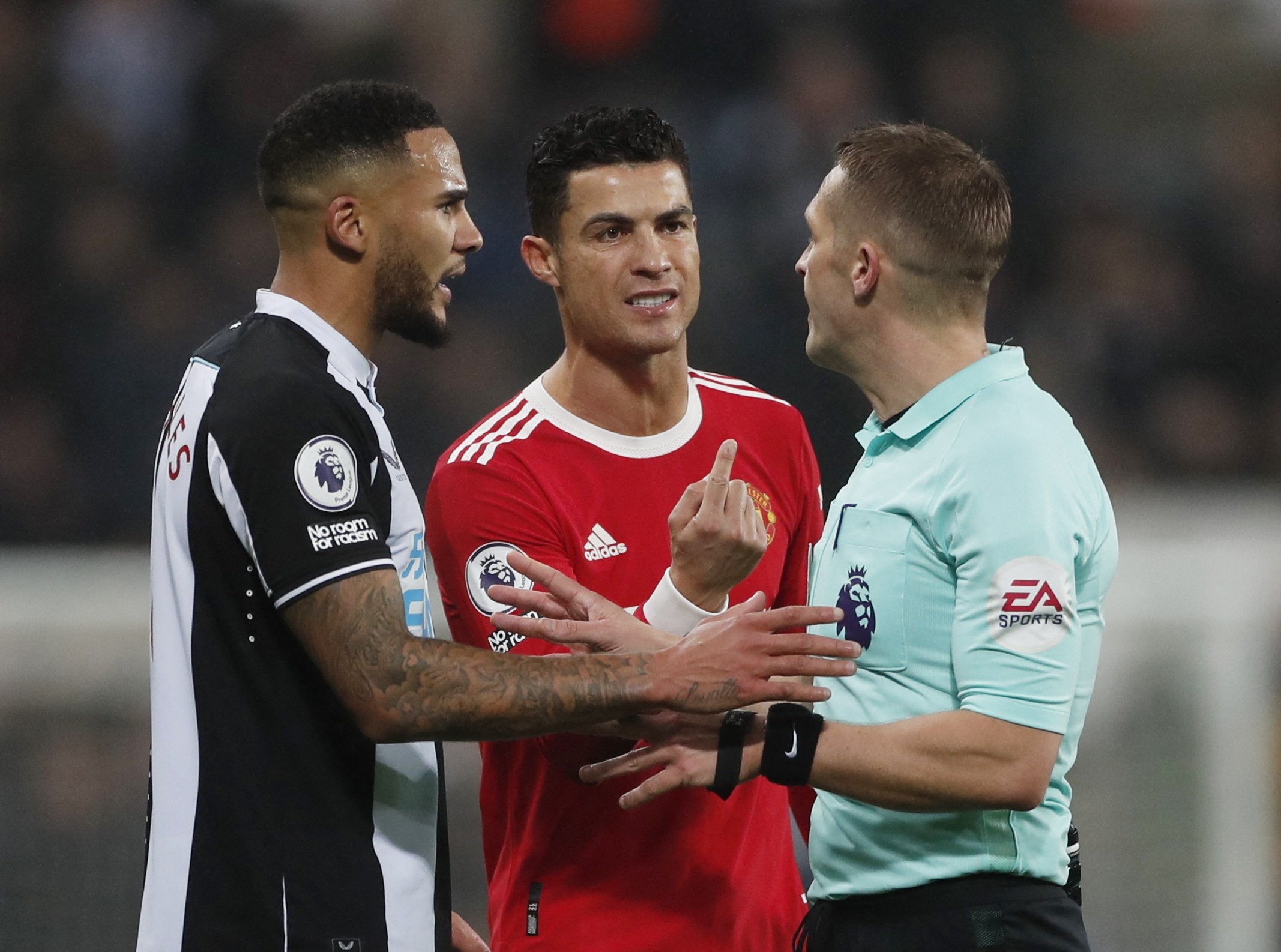 Man Utd's Cristiano Ronaldo (C) with referee Craig Pawson and Newcastle United's Jamaal Lascelles in a Premier League game against Newcastle at St. James' Park, Newcastle, England, Dec. 27, 2021. (Reuters Photo)