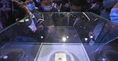 Visitors wearing masks look at the ARM-structure server processor Yitian 710, developed by Alibaba's in-house semiconductor unit T-Head, at the Apsara Conference, an annual cloud service technology forum hosted by Alibaba Group, in Hangzhou, Zhejiang province, east China, Oct. 19, 2021. (AP Photo)